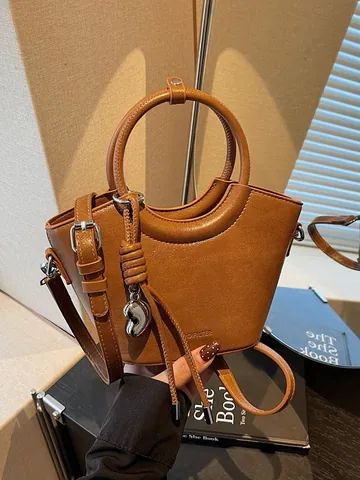 Bolso Cubo de Mujer de Cuero PU Minimalista Mango Circular Bolso de Mano Vintage Bolso Bandolera Con Colgante de Corazón Borla Color Sólido