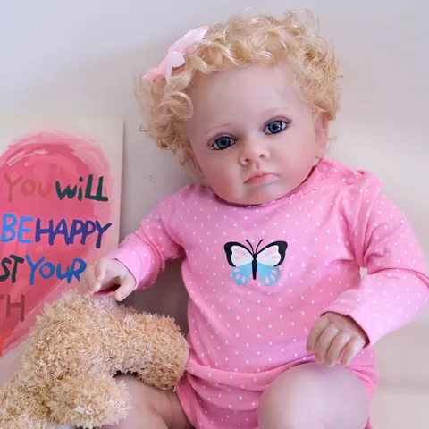 Poupée Reborn Réaliste 60cm Membres en Silicone Souple Corps en Coton Barboteuse Rose à Pois Papillon Cheveux Bouclés Or Yeux Bleus Peinte à la Main