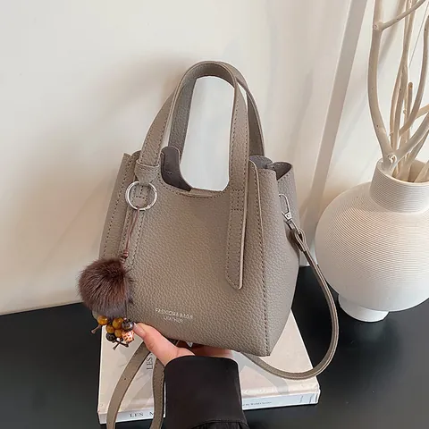 Borsa a Secchiello Donna in Pelle PU Trama Litchi Minimalista Semplice Borsa a Spalla Tracolla Con Pompon Ciondolo Shopping