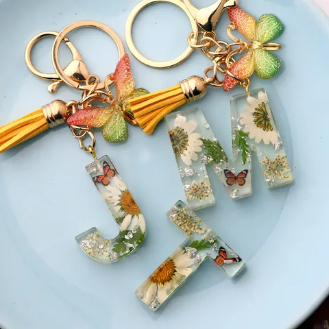 Χειροποίητο Μπρελόκ Αλφαβήτου από Ρητίνη Με Αληθινά Αποξηραμένα Λουλούδια Μενταγιόν Πεταλούδα Φούντα Ντεγκραντέ Γράμμα Α-Ω Μπρελόκ Αξεσουάρ Διακόσμησης Τσάντας για Γυναίκες