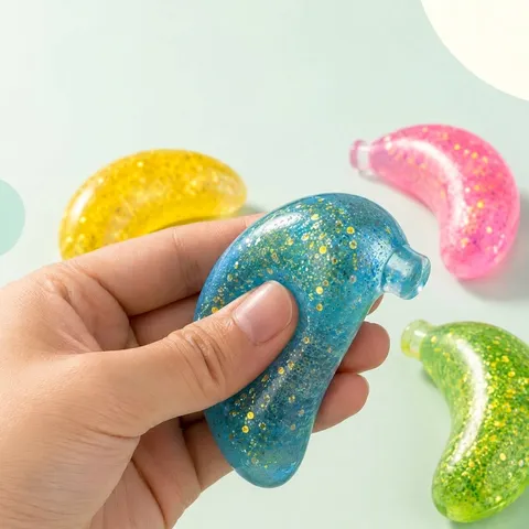 Joli Jouet Squishy en TPR en Forme de Banane Paillettes Translucides Jouet Anti-stress pour Bureau Quotidien Adultes Enfants Décoration