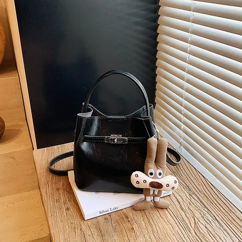 Damen PU Leder Eimer Tasche Minimalistische Pendler Handtasche Mode Metall Drehverschluss Umhängetasche Mit Plüsch Anhänger