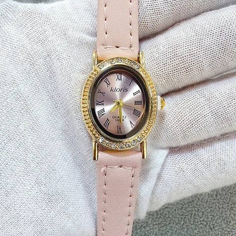 Montre à Quartz Élégante pour Femme Boîtier Ovale en Strass Cadran Classique Chiffres Romains Bracelet en Similicuir Montre Décontractée
