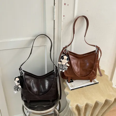 Vintage PU-Leder Umhängetasche für Damen Trendige Crossbody Schultertasche mit Puppenanhänger Vielseitige Tasche für den Alltag