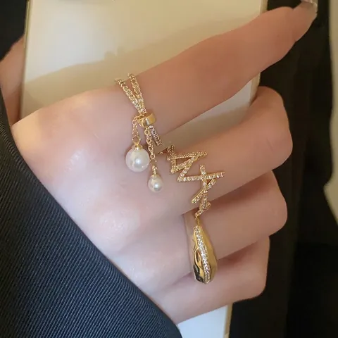 Anillo Aperto A Doppio Strato Sfalsato In Rame Placcato Oro Con Zirconi E Pendenti Con Nappine Di Künstliche Perle Regolabile