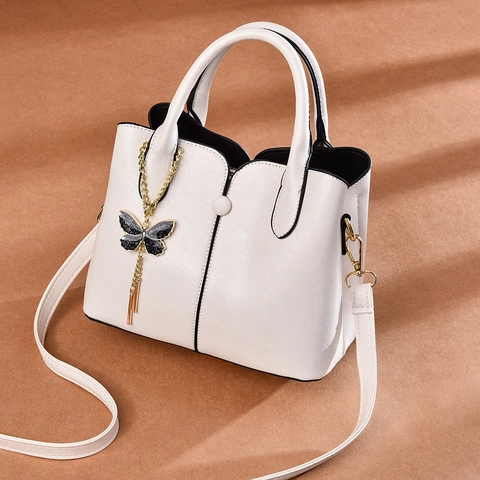 Sac À Main De Mode En Cuir PU Pour Femmes Grain De Litchi Sac À Bandoulière Avec Pendentif Papillon Gland Bord Contrasté