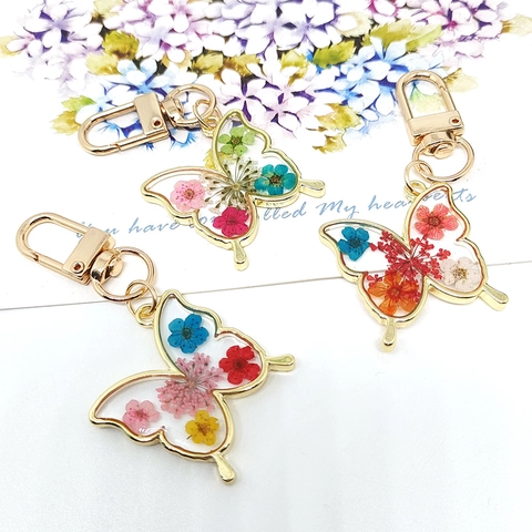 Llavero De Mariposa Con Flores Secas Reales Resina Transparente Marco De Aleación De Oro Colante Estilo Pastoral